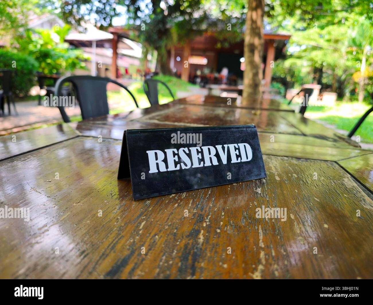 Reserviertes Schild auf einem Holztisch in einem Restaurant im Freien Stockfoto