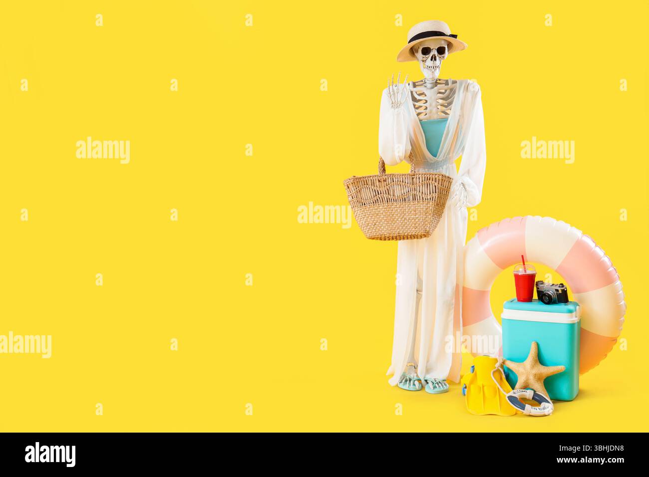 Menschliches Skelett mit Strandzubehör auf gelbem Hintergrund Stockfoto