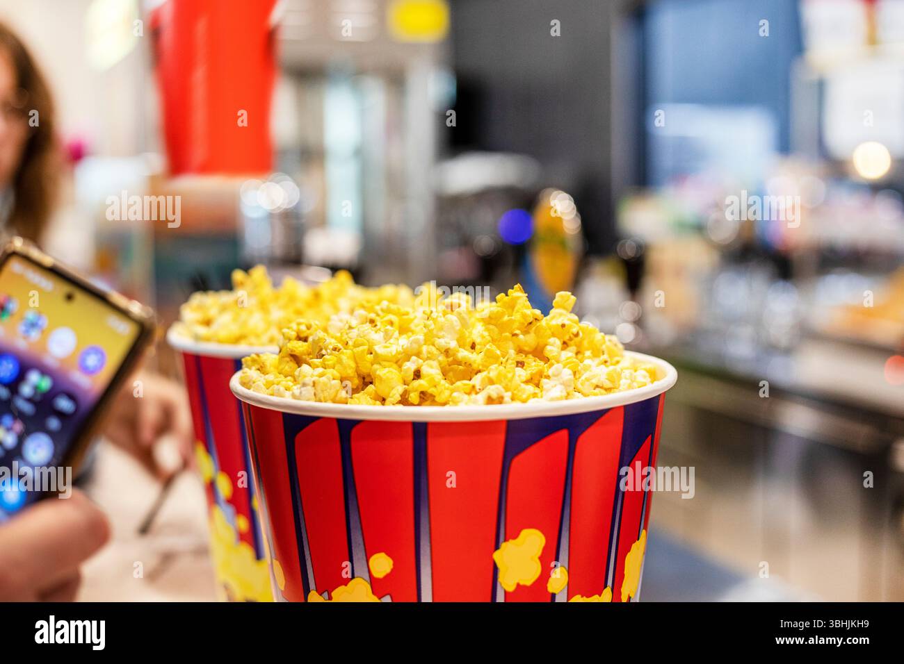 Kaufen Sie Popcorn, um sich einen Film auf Ihrem Handy anzusehen Stockfoto