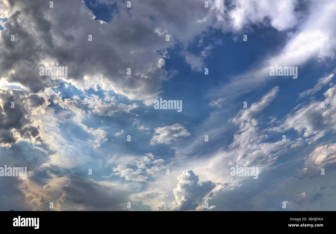 Malerischer Blick auf einen bewölkten Himmel mit sanftem Licht und blauen Highlights. Perfekt für beruhigende und ruhige Atmosphären in Kopfzeilen oder Panoramadisplays. Stockfoto