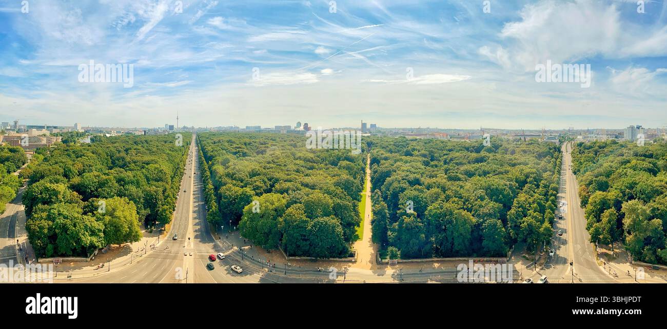Weites Panorama mit einem lebhaften grünen Park inmitten einer urbanen Landschaft unter hellem Himmel. Stockfoto