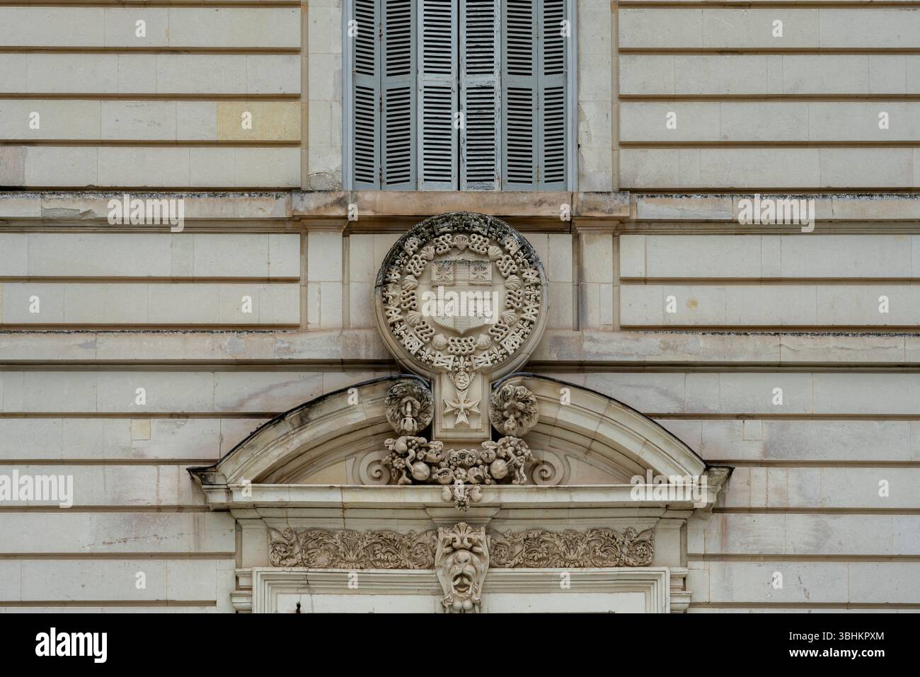 Das kunstvolle Steinwappen zeigt königliche Wappensymbole mit kunstvollen skulpturalen Details an der Außenfassade von château. Stockfoto