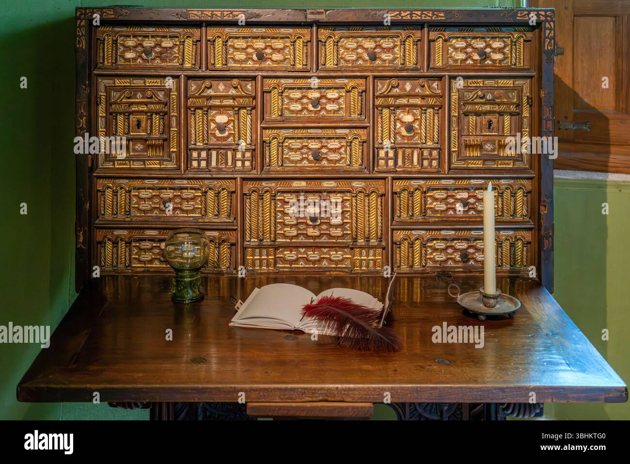 Der kunstvoll verzierte goldene Schrank verfügt über raffinierte geometrische Muster und aufwändige Renaissance-Holzarbeiten mit mehreren dekorativen Fächern. Stockfoto