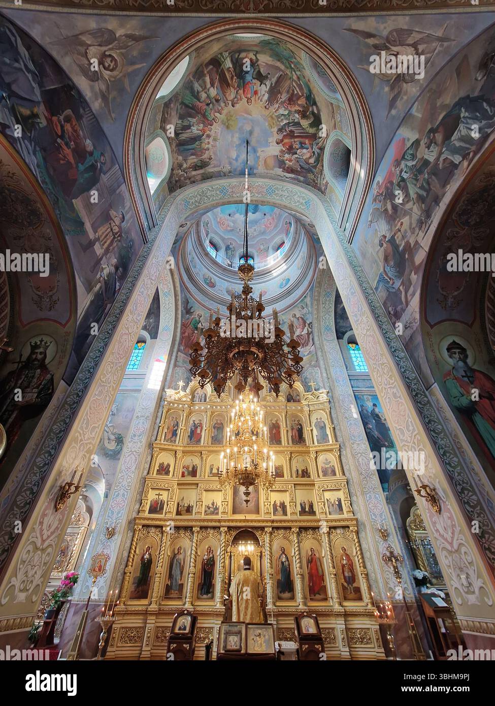 Das Capriana-Kloster bietet einen Innenblick auf die traditionelle, kunstvoll verzierte christlich-orthodoxe Kirche in Moldau. Szene während des Gottesdienstes mit einem Mönch, der betet - Smartphone-aufgenommenes Stockfoto