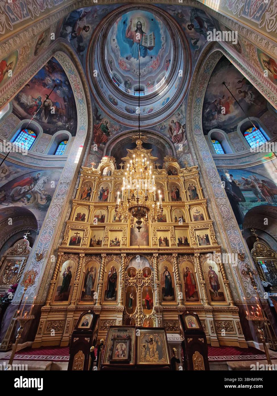 Das Capriana-Kloster bietet einen Innenblick auf die traditionelle, kunstvoll verzierte christlich-orthodoxe Kirche in Moldau. Szene während des Gottesdienstes mit einem Mönch, der betet - Smartphone-aufgenommenes Stockfoto