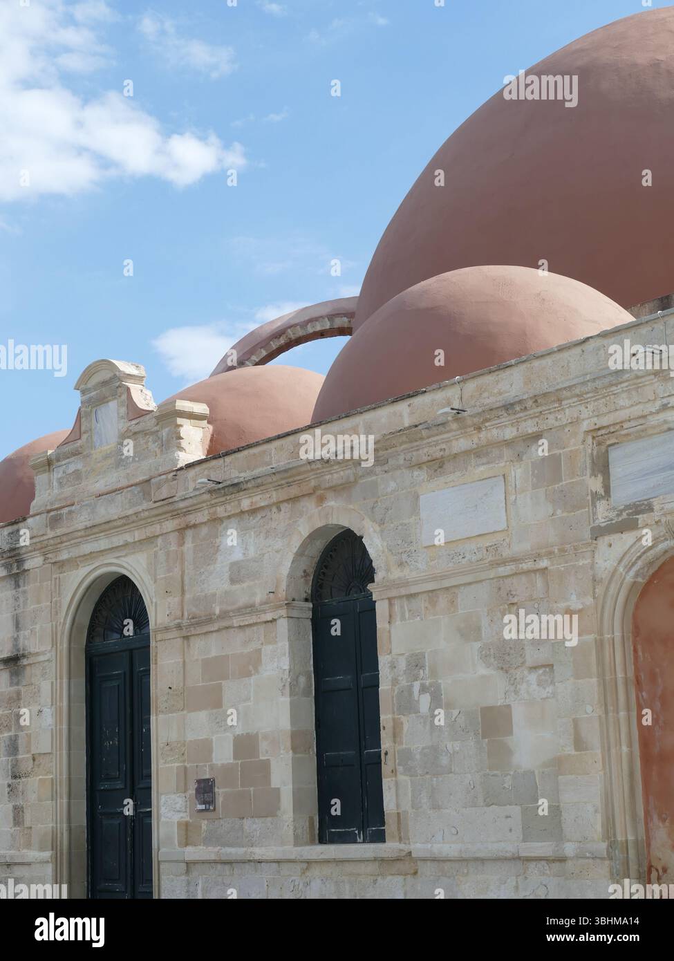 CHANIA, KRETA - 5. MAI 2025 - flacher architektonischer Blick mit den charakteristischen Terrakottatuppeln der historischen Moschee von Neratze, die sich gegen das klare CR erheben Stockfoto