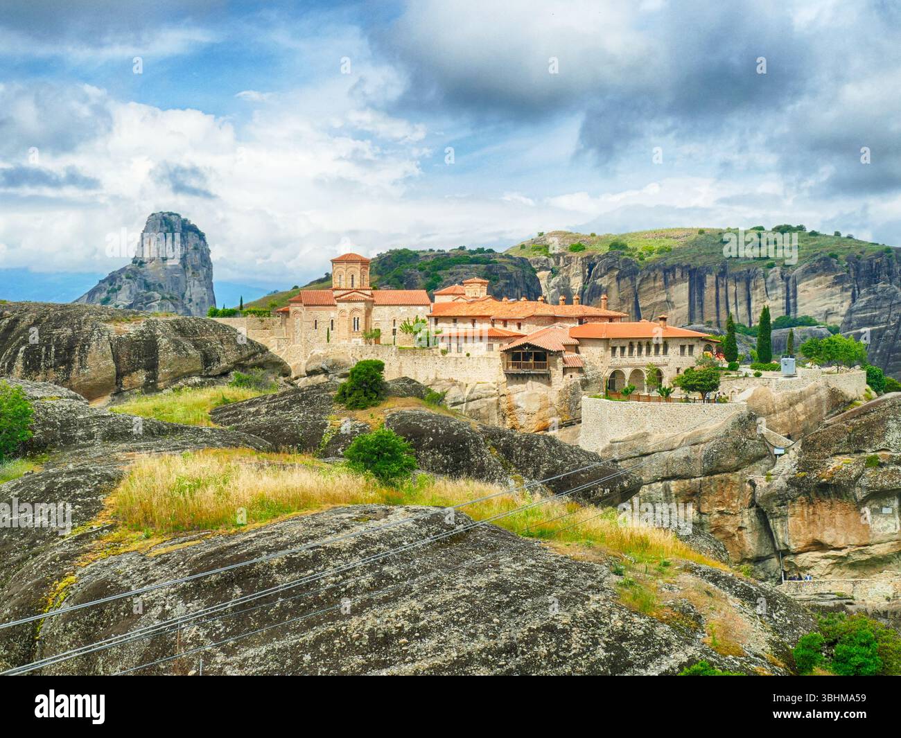 METERORA, GFEECE - 11. MAI 2025 - das Heilige Kloster des Heiligen Nikolaus Anapausas genießt seine markante Lage auf dem hohen Felsen in Meteora, umgeben von der Stadt Stockfoto