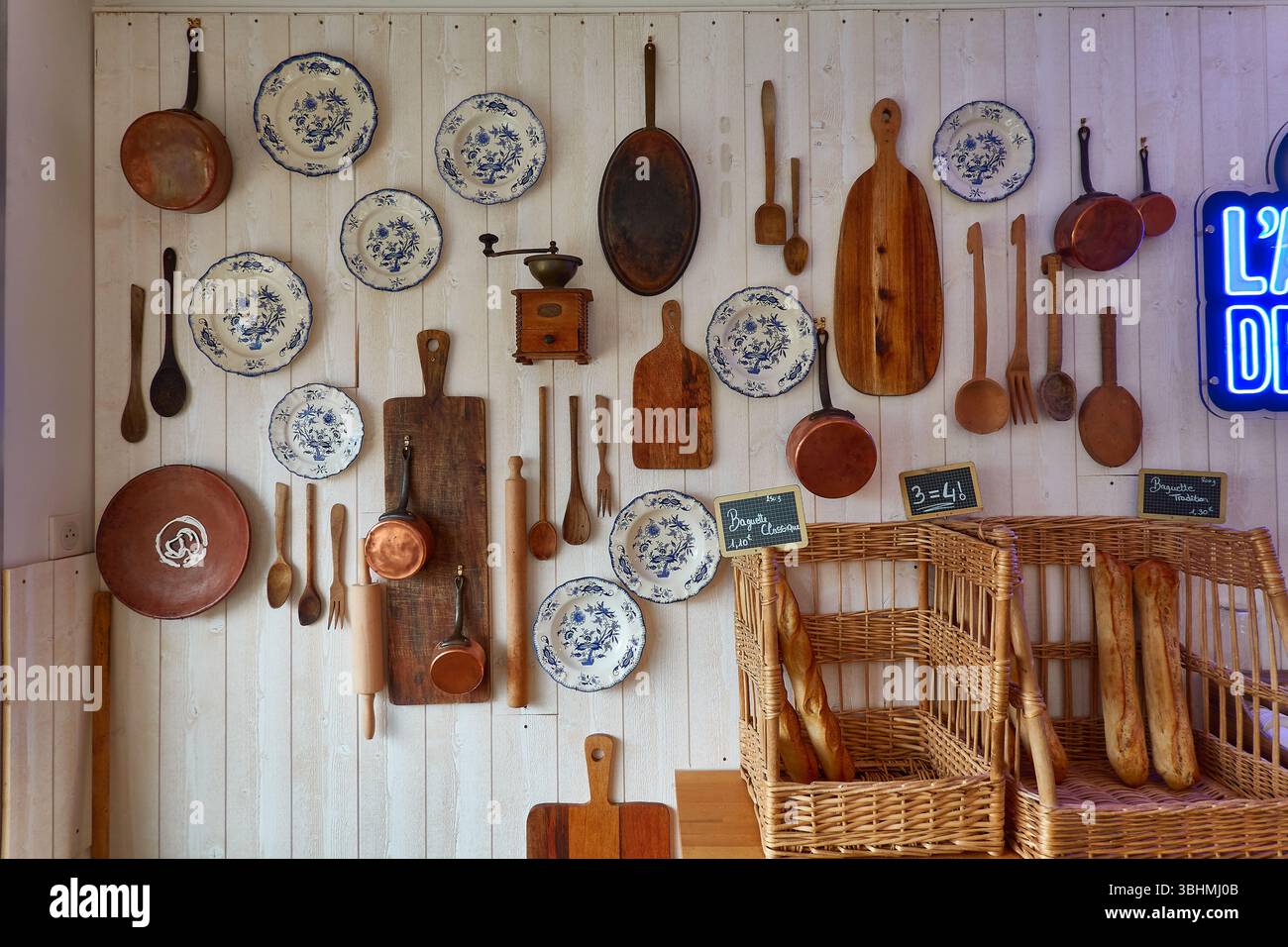 Rustikale französische Bäckerei mit Baguettes, Utensilien und Wanddekor Stockfoto