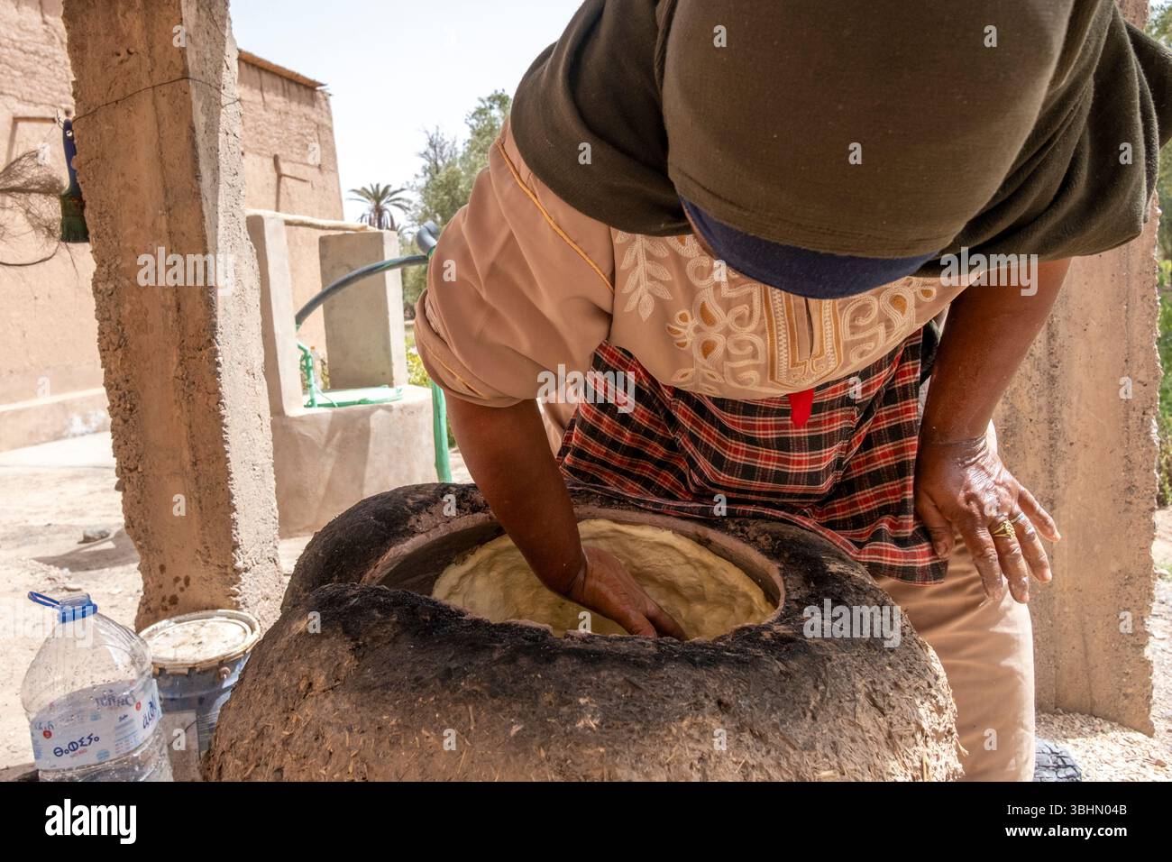 Eine Frau, die Brot in einem traditionellen Ofen backt. Skoura, Provinz Ahl El Oust, Marokko. Stockfoto