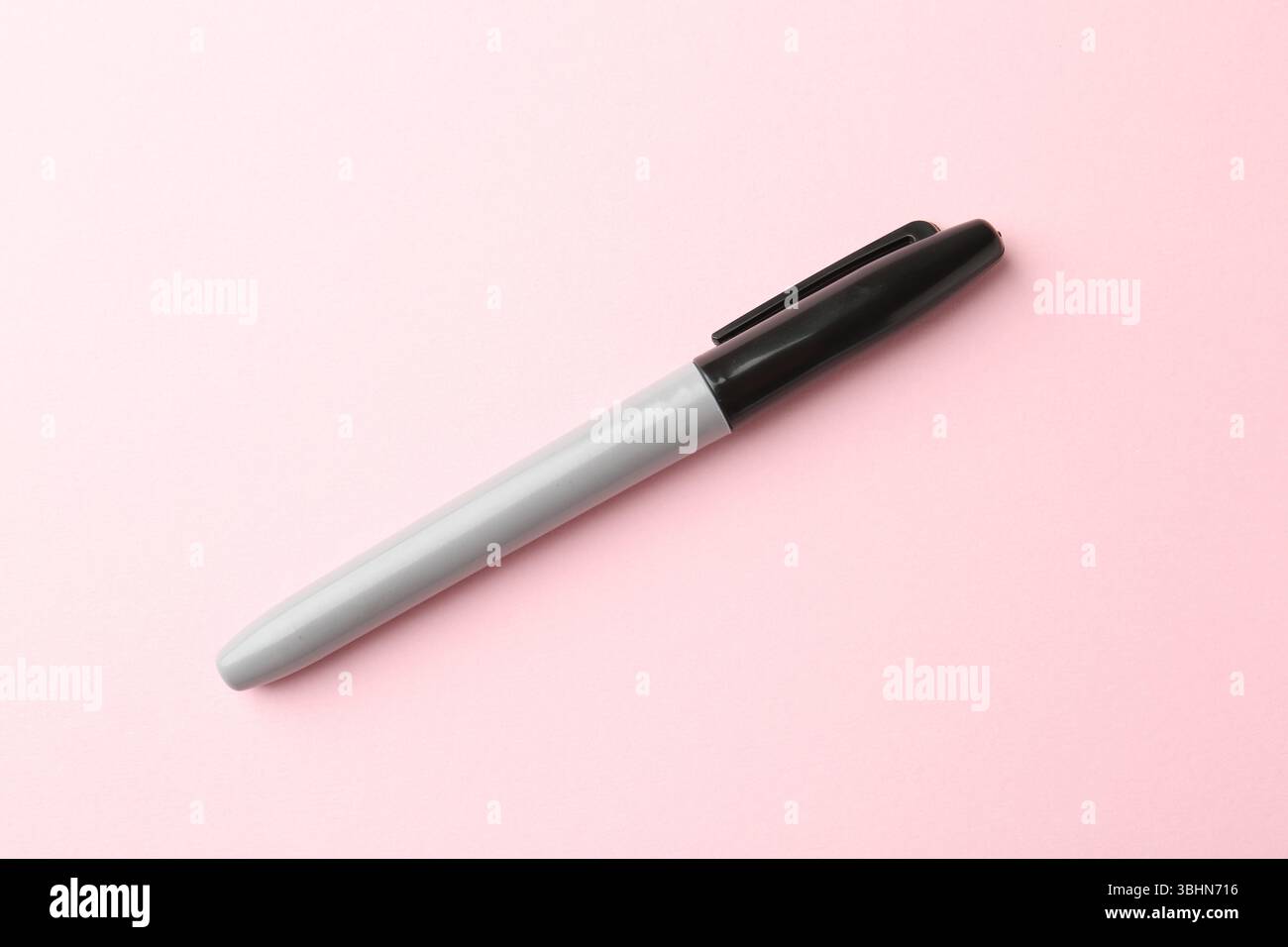 Ein schwarzer Marker auf hellrosa Hintergrund, Draufsicht Stockfoto