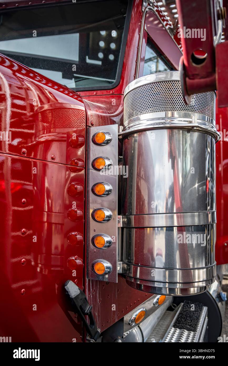 Roter großer Lkw-Sattelzugmaschine mit zweistufigem hydraulischem Auflieger, der auf dem Lagerparkplatz steht und auf die Ladung wartet Stockfoto