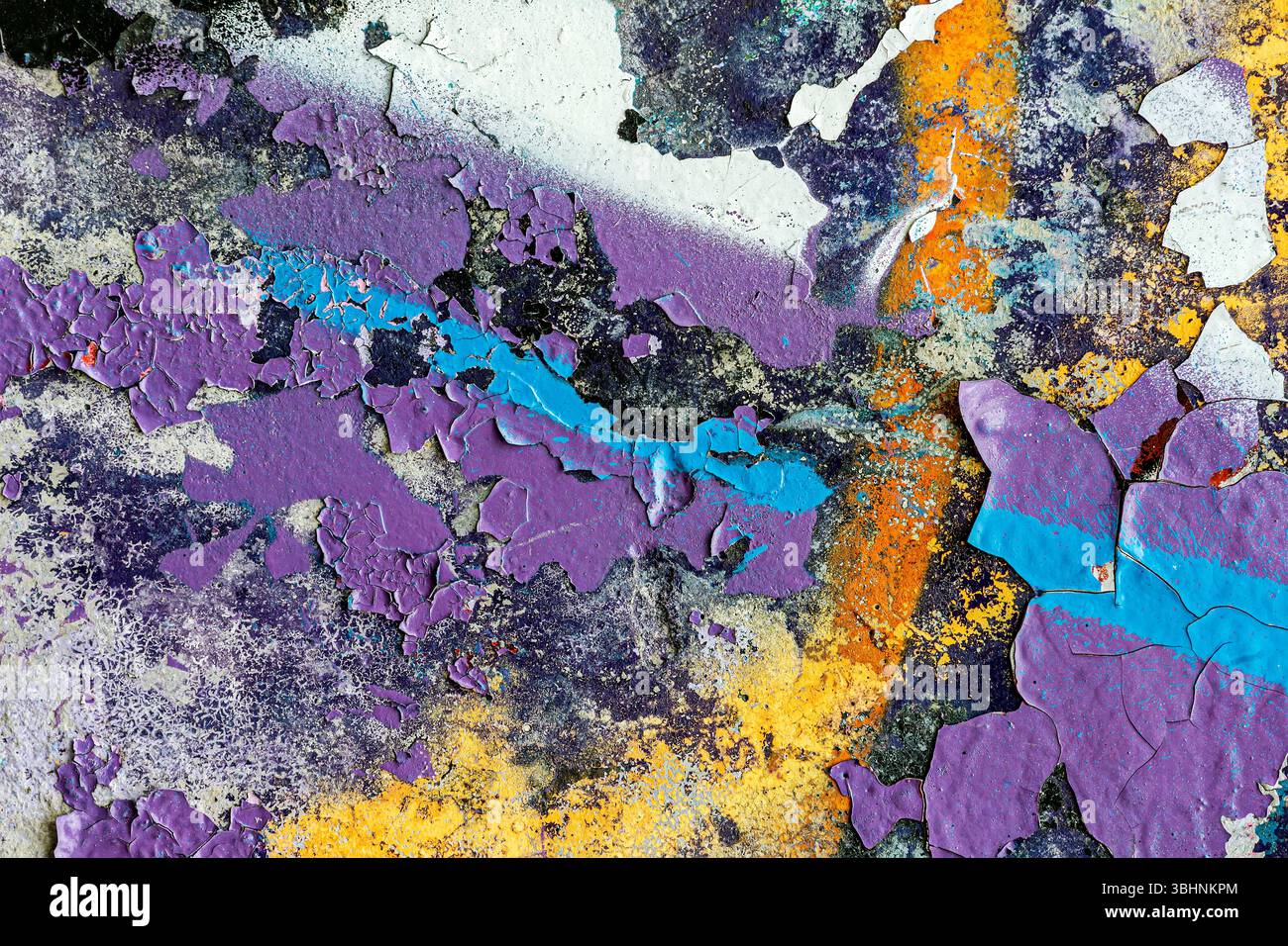 Schleifende Betonwandoberfläche mit abblätternder Farbe. Teil von farbenfrohen Straßengraffiti. Stockfoto