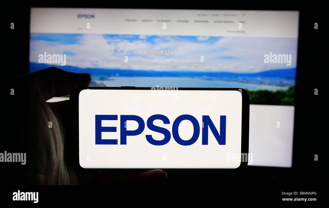 Stuttgart, Deutschland - 18.03.2025: Person, die ein Mobiltelefon mit dem Logo des Elektronikunternehmens Seiko Epson Corporation auf dem Bildschirm vor der Webseite hält. Stockfoto