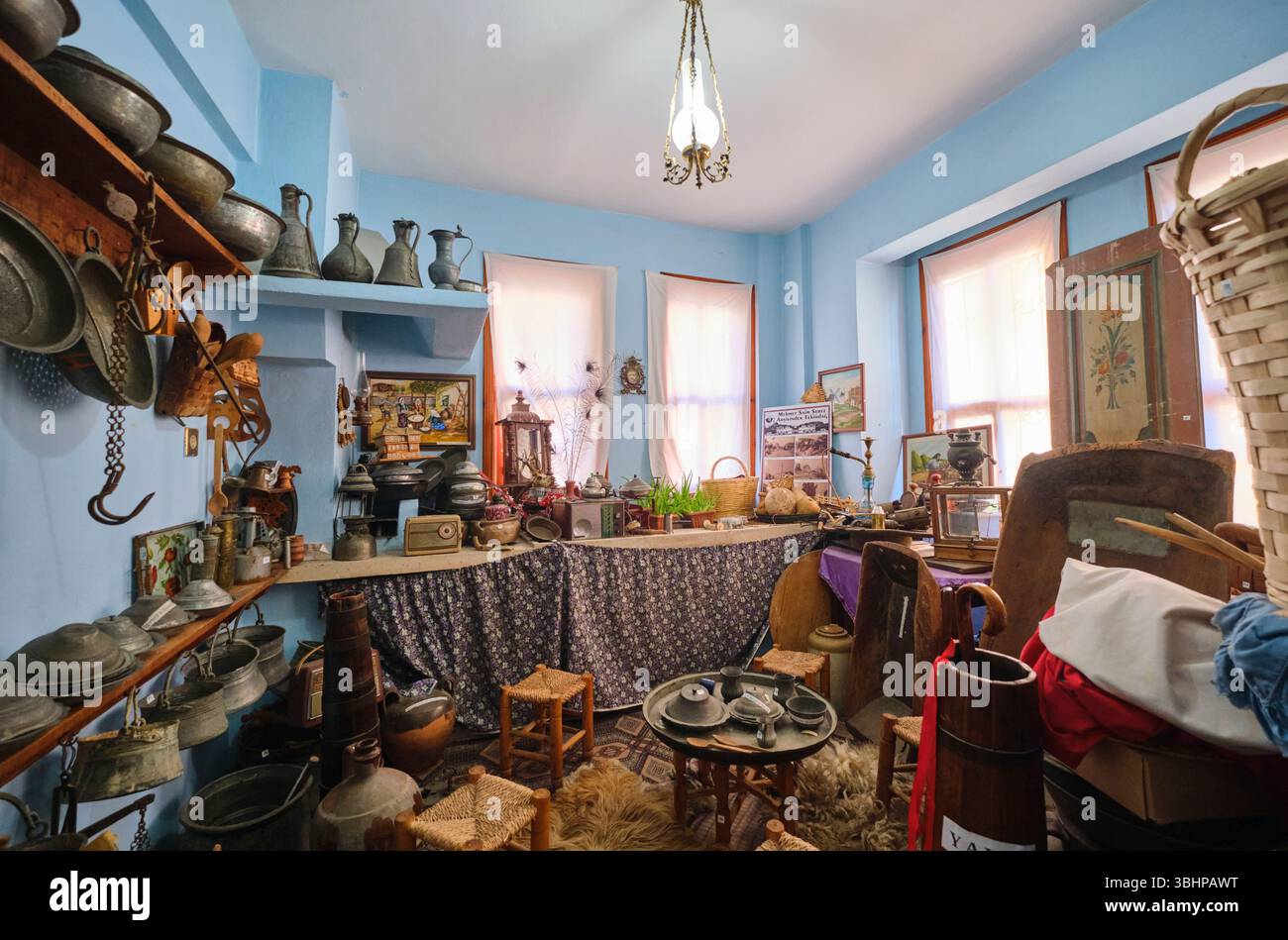 Ein alter Küchenraum, gefüllt mit alten Schüsseln, Metallkochgeschirr und anderen Lebensmitteln. Im Namik Kemal House Museum in Tekirdag, Türkei. Stockfoto