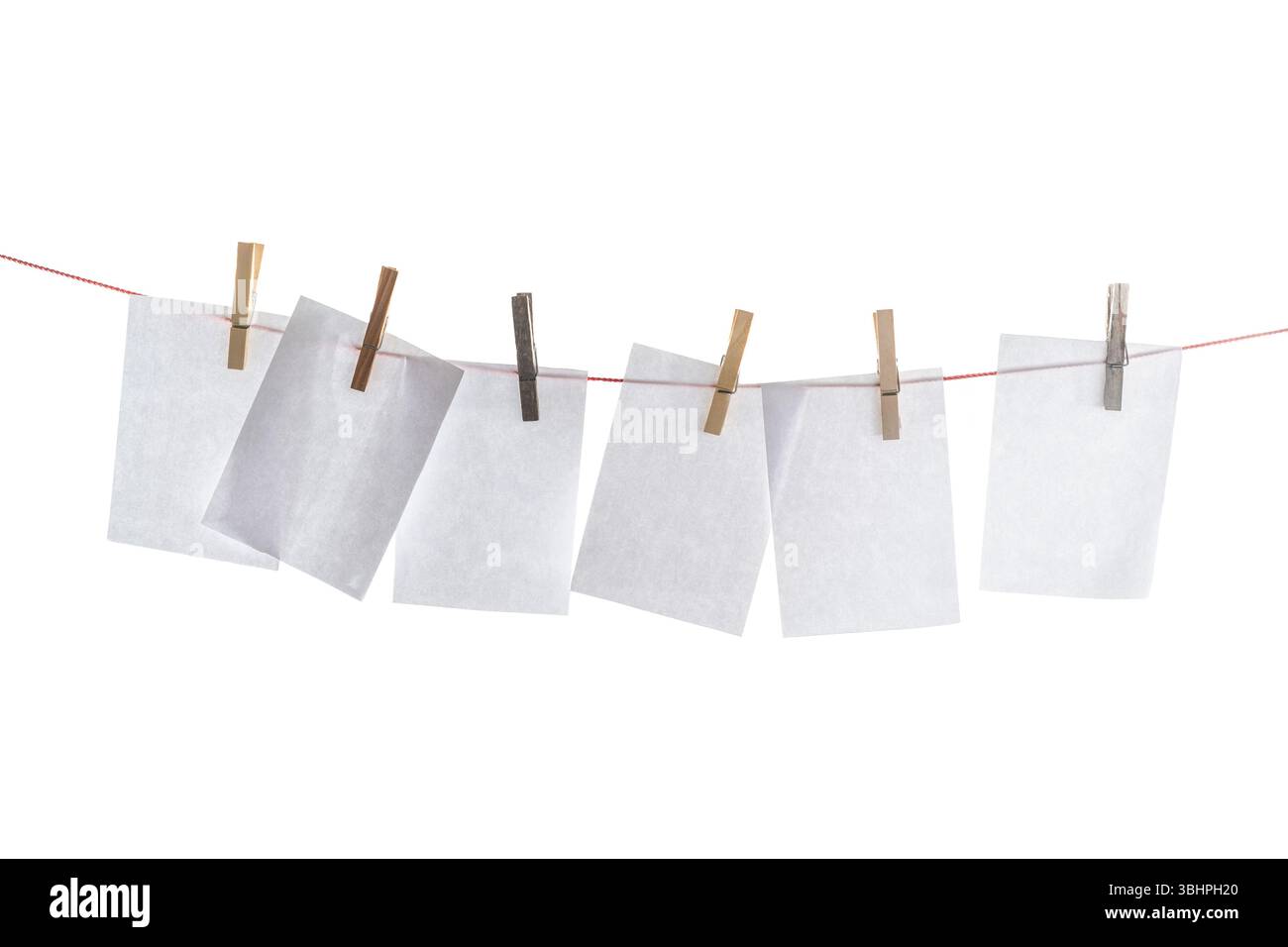 Wäscheleine mit leeren Papierbögen, die mit hölzernen Kleiderschränken auf weißem Hintergrund aufgehängt wurden, nachgeahmt, Kopierraum Stockfoto