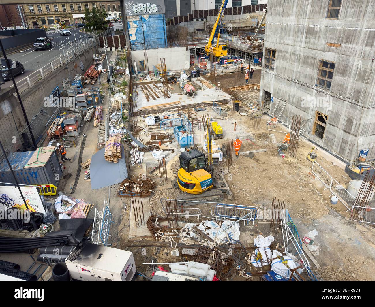 Eine geschäftige Baustelle mit Maschinen, Materialien und Arbeitern, umgeben von städtischer Infrastruktur und Gebäuden newcastle upon tyne uk - Smartphone-aufgenommenes Stockfoto