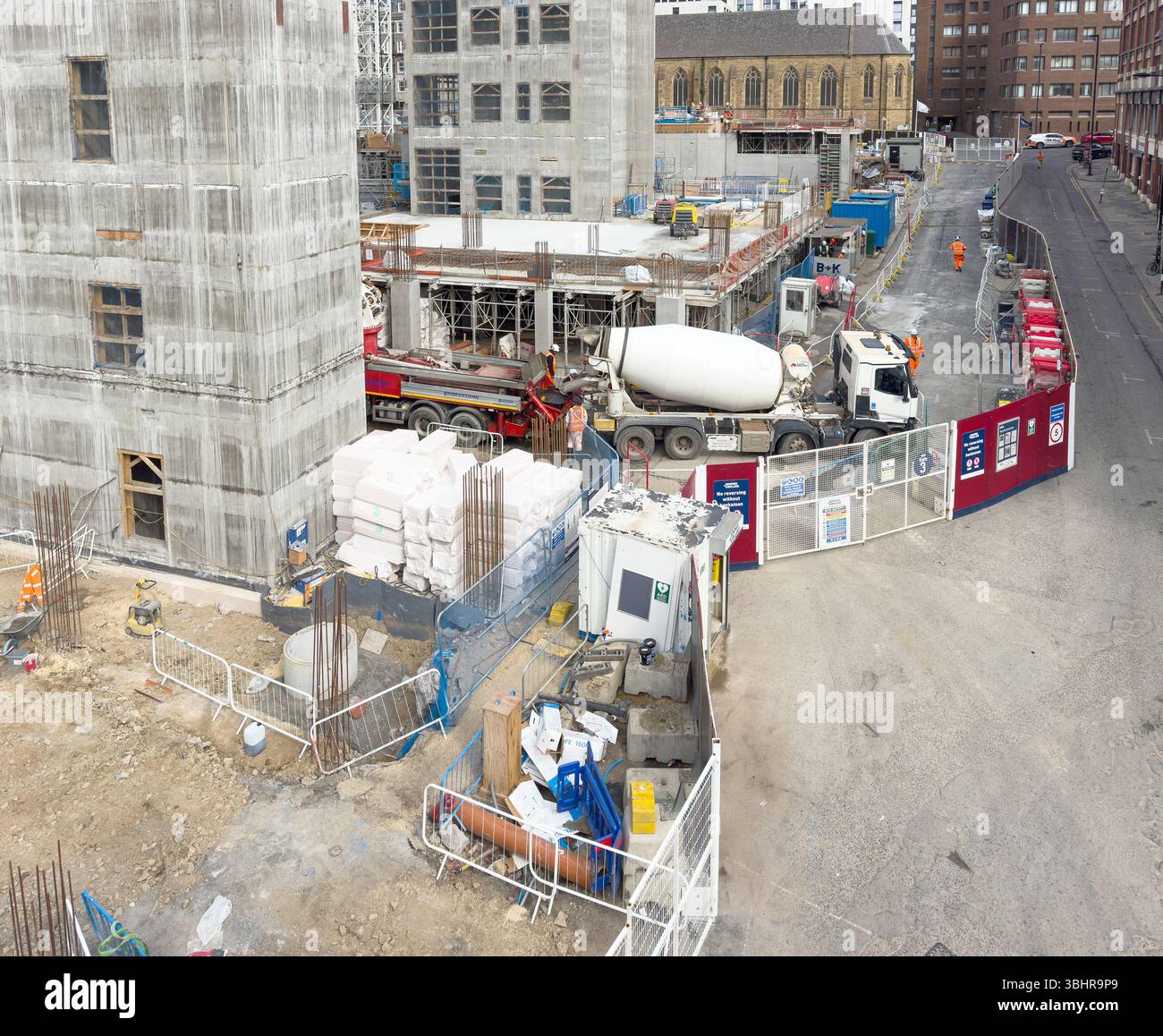Eine geschäftige Baustelle mit Maschinen, Materialien und Arbeitern, umgeben von städtischer Infrastruktur und Gebäuden newcastle upon tyne uk - Smartphone-aufgenommenes Stockfoto