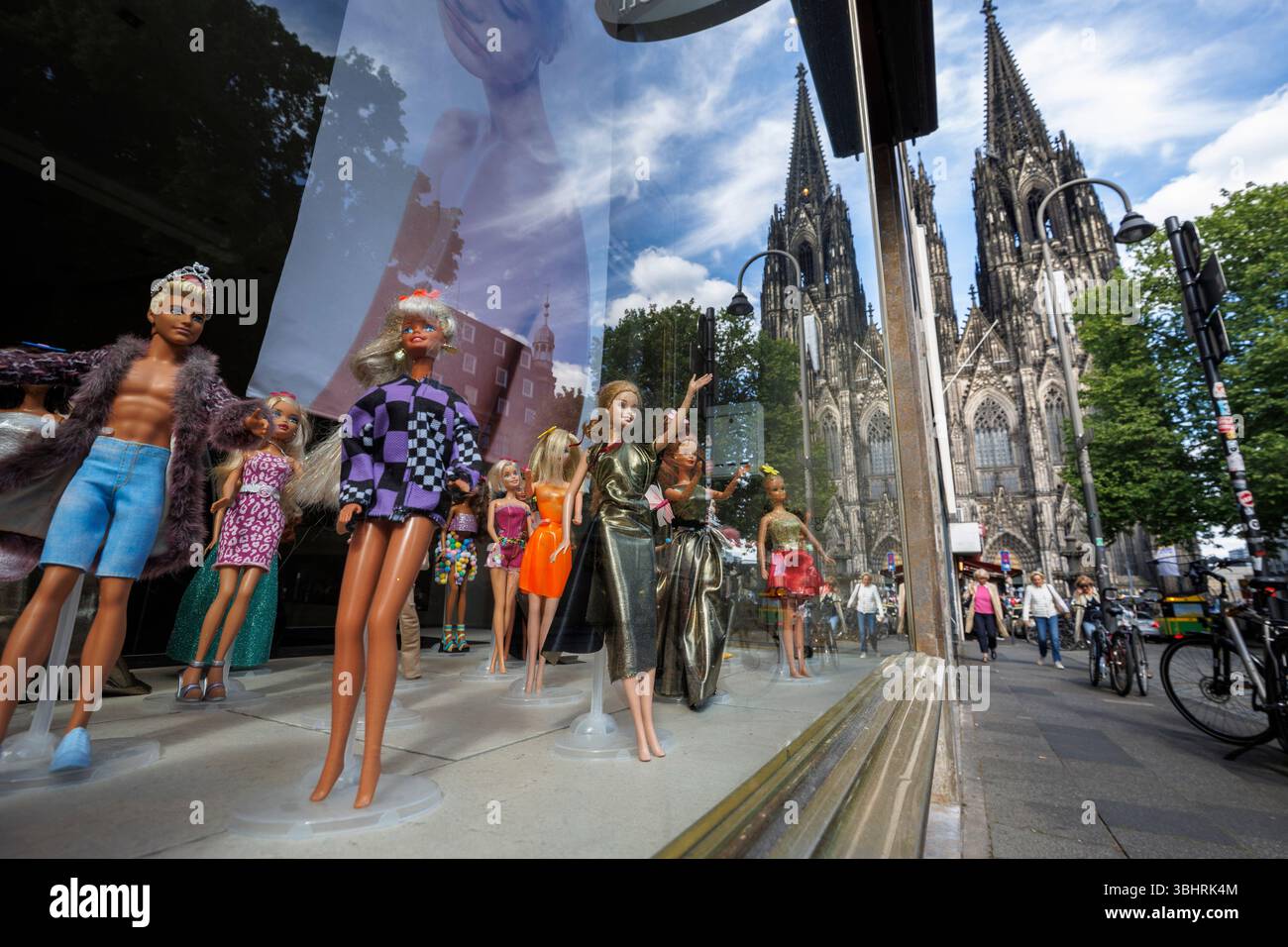 Mit Barbie-Puppen dekorierte Schaufenster eines Friseursalons in der Nähe des Doms in Köln. mit Barbie Puppen dekoriertes Schaufenster eine Stockfoto