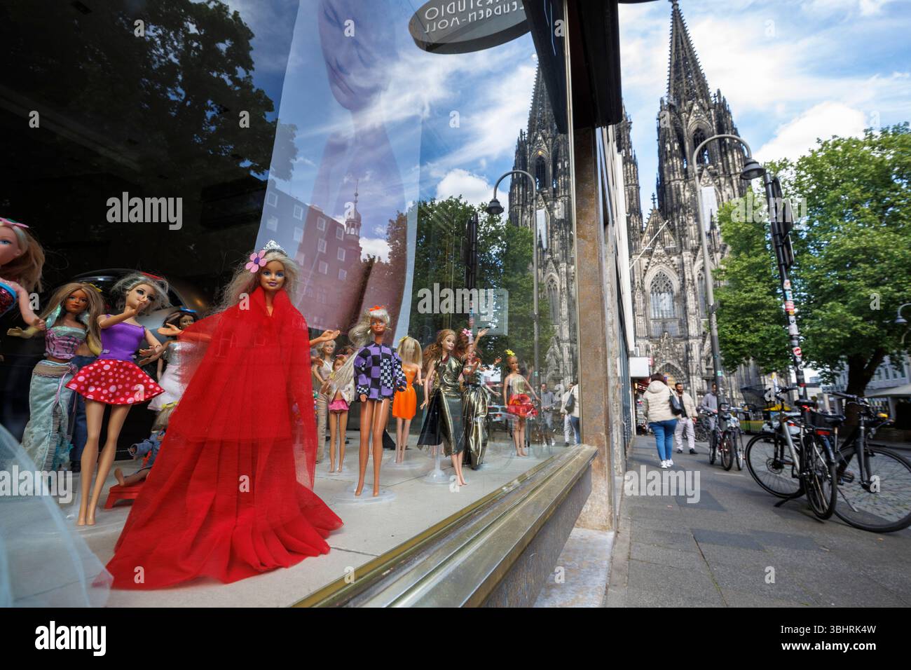 Mit Barbie-Puppen dekorierte Schaufenster eines Friseursalons in der Nähe des Doms in Köln. mit Barbie Puppen dekoriertes Schaufenster eine Stockfoto
