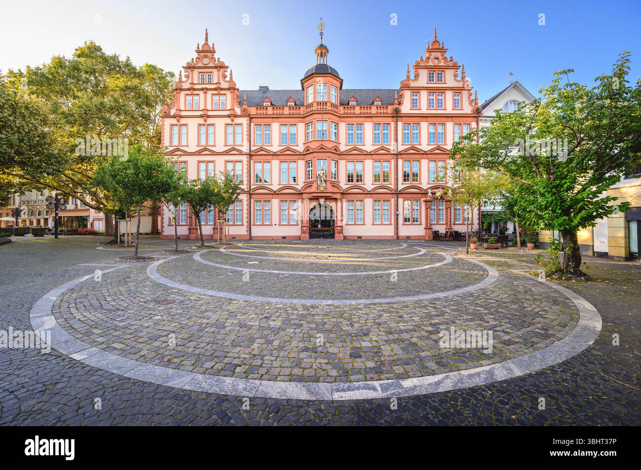 Besucher bewundern die elegante Fassade des Gutenberg-Museums in Mainz unter klarem blauen Himmel. Stockfoto