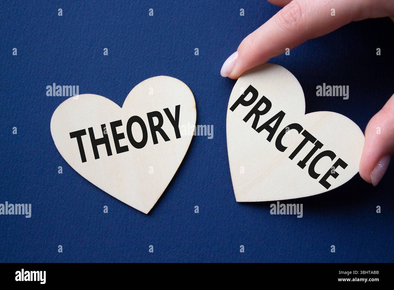 Theorie- oder Praxissymbol. Konzeptwort Theorie oder Praxis auf hölzernen Herzen. Geschäftsmann Hand. Wunderschöner tiefblauer Hintergrund. Business und Theorie oder Stockfoto