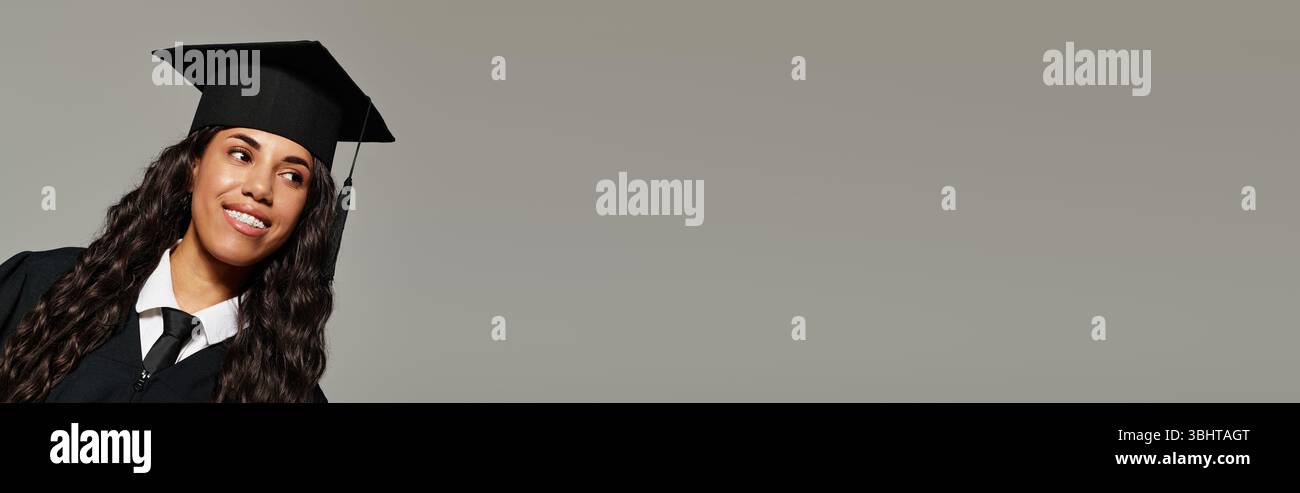 Lächelnde Frau in Abschlusskleidung drückt Glück in einem stolzen Moment der Leistung aus. Stockfoto