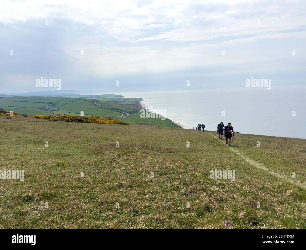 3. MAI 2025 - Isle of Wight, Großbritannien - Wanderer und Wanderer, die an einem Rundgang um die Isle of Wight teilnehmen, mit Blick auf das Meer bis zu den Needles an Stockfoto