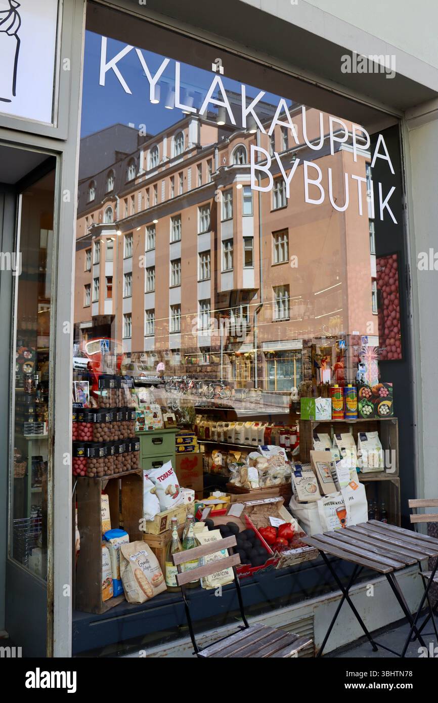 Reflexionen im Schaufenster von Kyläkauppa, by Butik, kleiner Delikatessenmarkt am Museokatu im Zentrum von Helsinki, Finnland, Mai 2025 Stockfoto