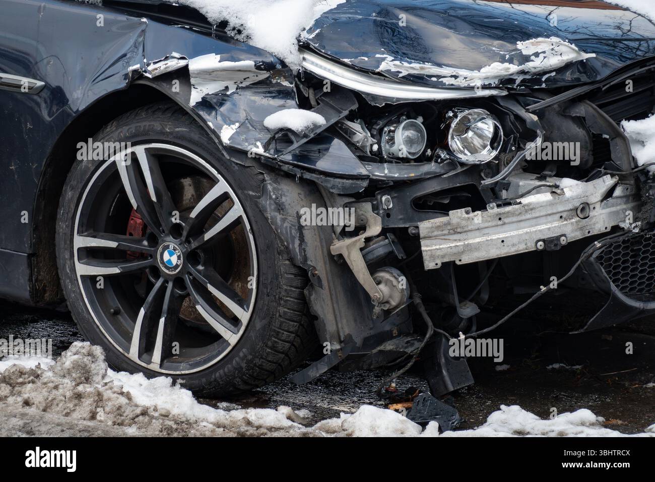OSTRAVA, TSCHECHIEN - 14. JANUAR 2024: Detail eines defekten Scheinwerfers und Stoßfängers am dunklen BMW 5-Wagen nach einem Verkehrsunfall Stockfoto