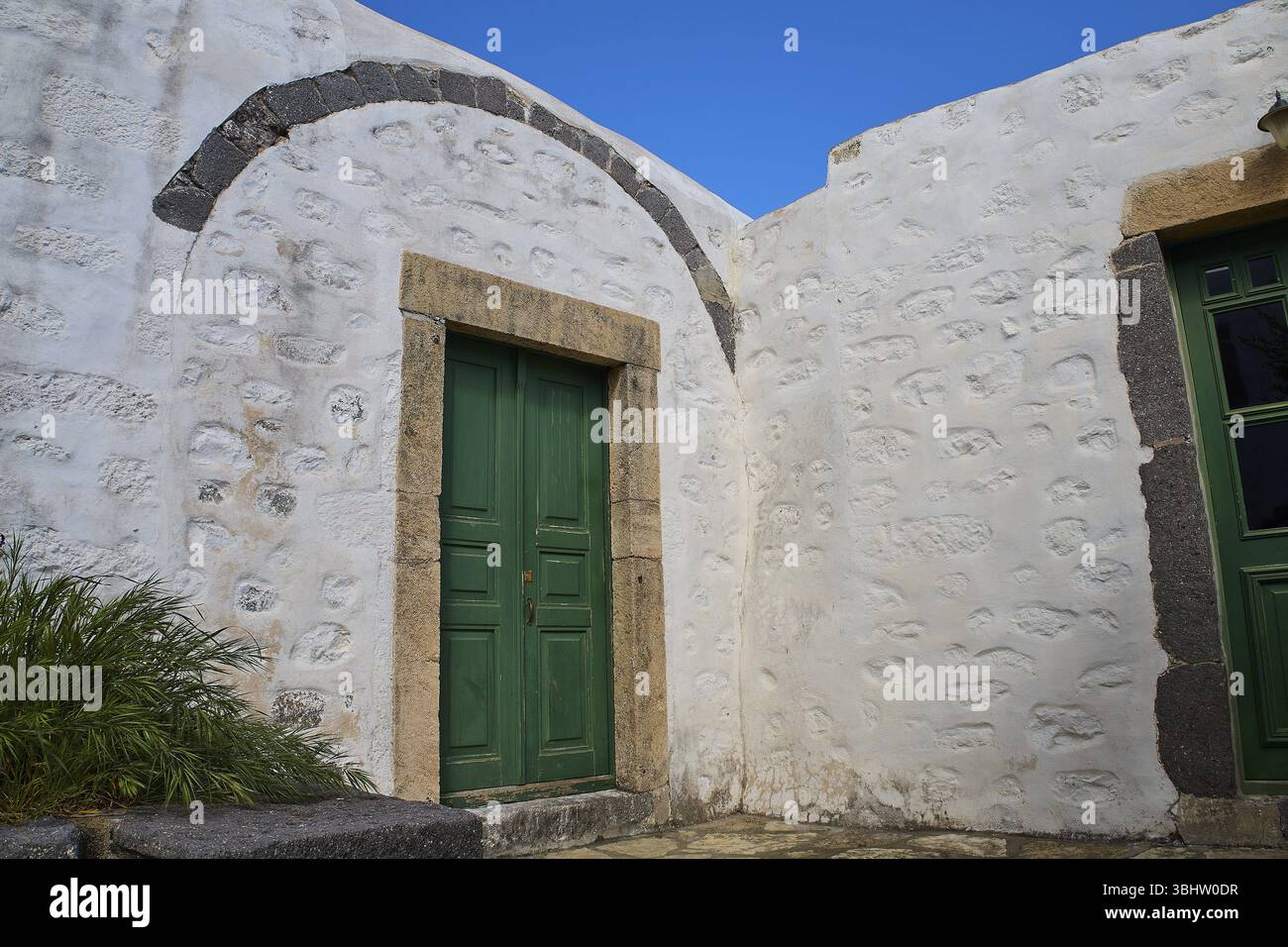 Grüne Holztür in einer dicken, weiß getünchten Mauer unter blauem Himmel, Kloster der Offenbarung, Moni tis Apokalipsis, Weltkulturerbe 1999, Patmos, Stockfoto