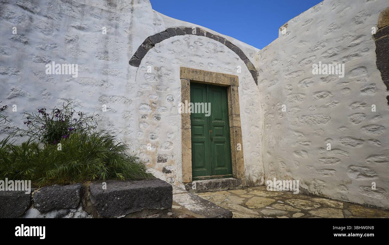 Grüne Tür in einem Innenhof mit Pflanzen und weiß getünchten Wänden, Kloster der Offenbarung, Moni tis Apokalipsis, Weltkulturerbe 1999, Patmos, Dode Stockfoto