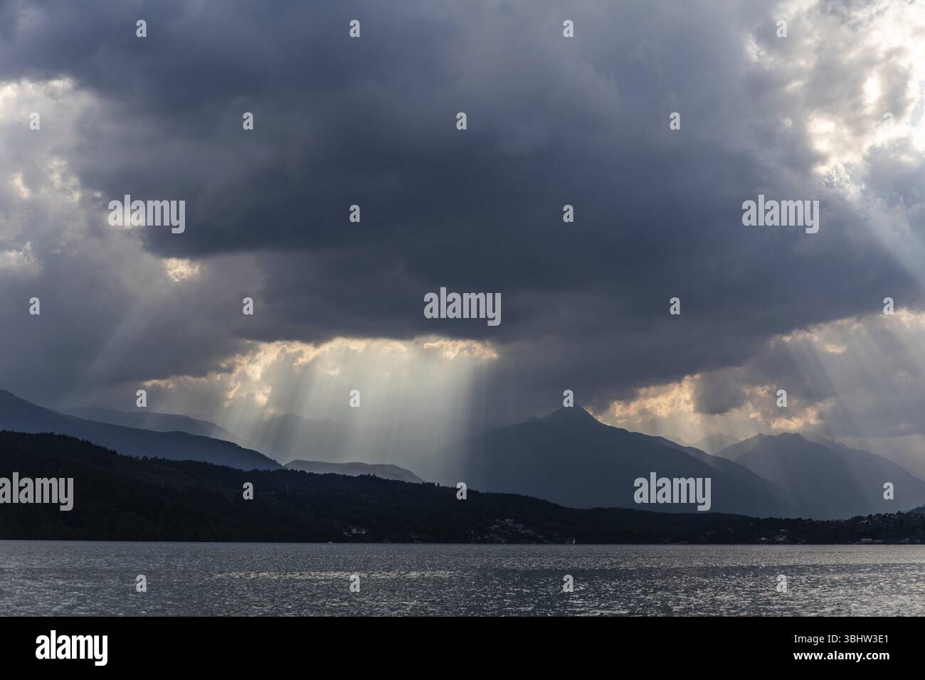 Bewölkte Stimmung über dem Millstättersee, Sonnenstrahlen aus Wolken, bei Millstatt, Kärnten. Österreich Stockfoto