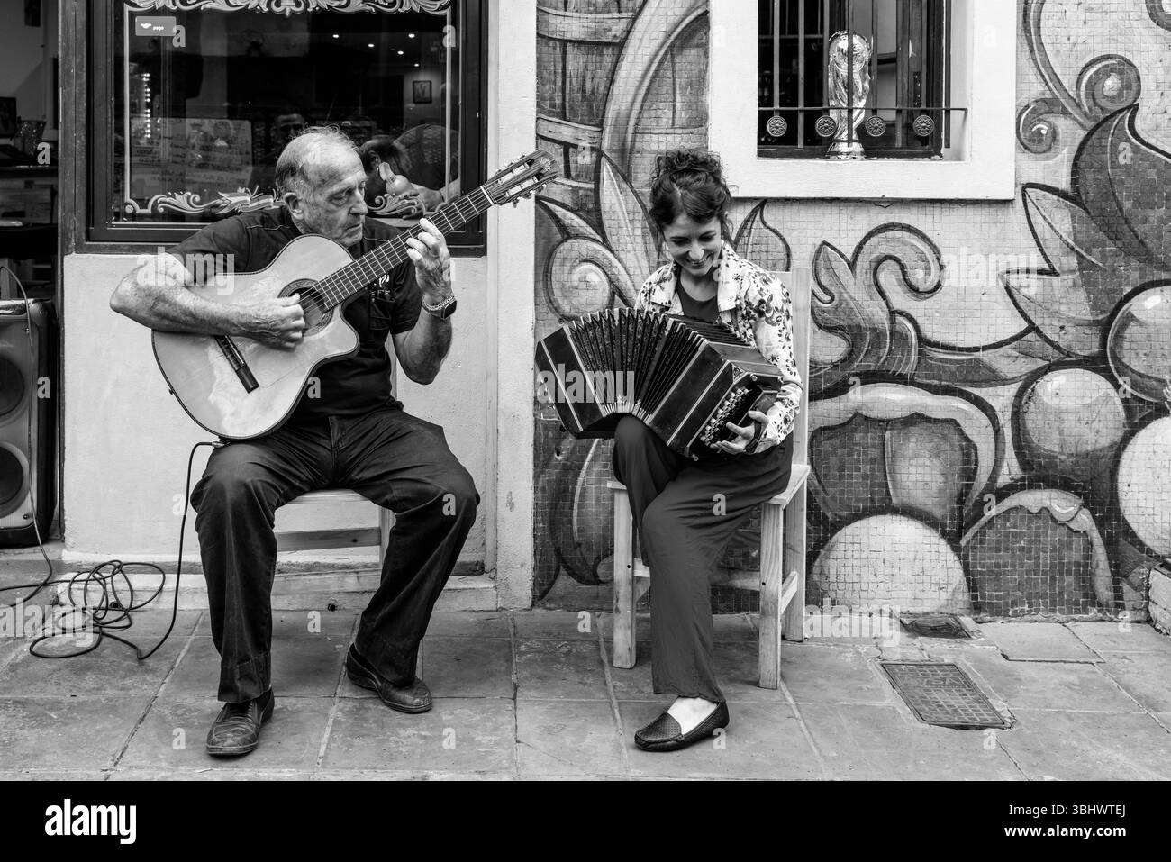Zwei Musiker spielen vor Einem Restaurant im farbenfrohen Viertel La Boca in Buenos Aires, Argentinien. Stockfoto