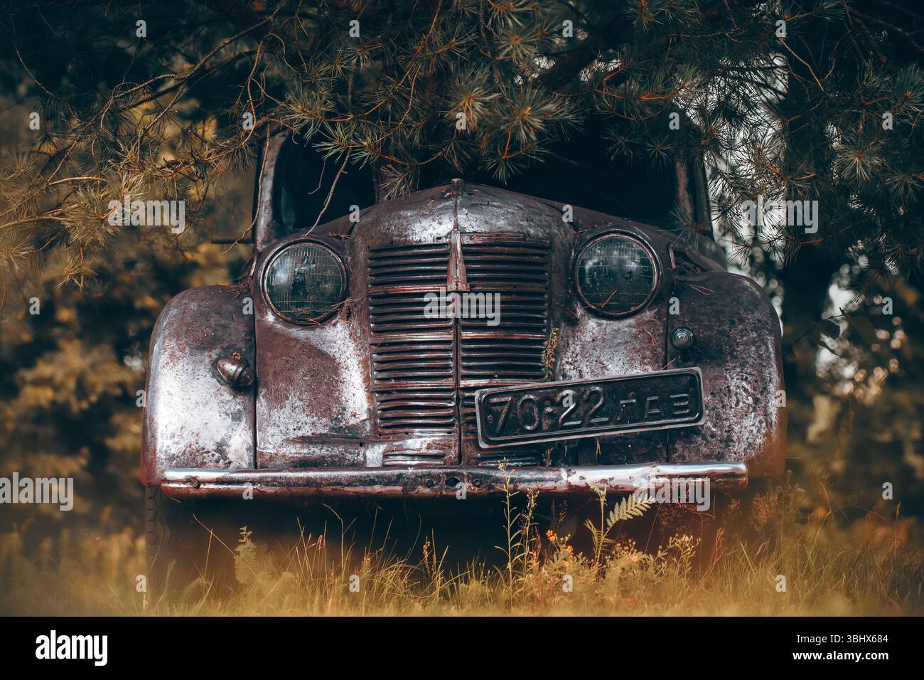 Altes sowjetisches rostiges Auto im Wald verlassen Stockfoto