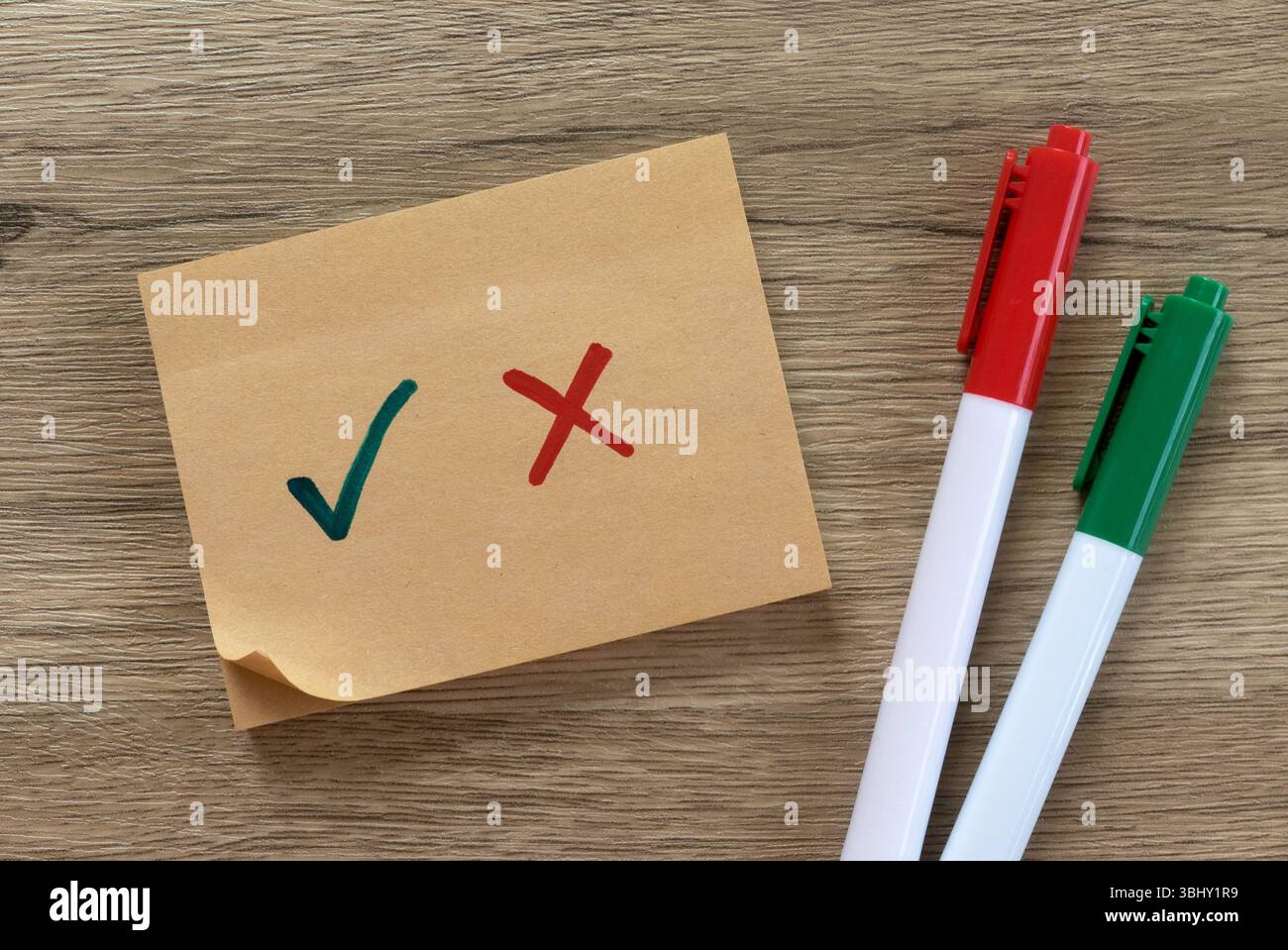 Checkliste mit grünem Häkchen und rotem Kreuz auf Haftnotiz mit Stiften. Stockfoto