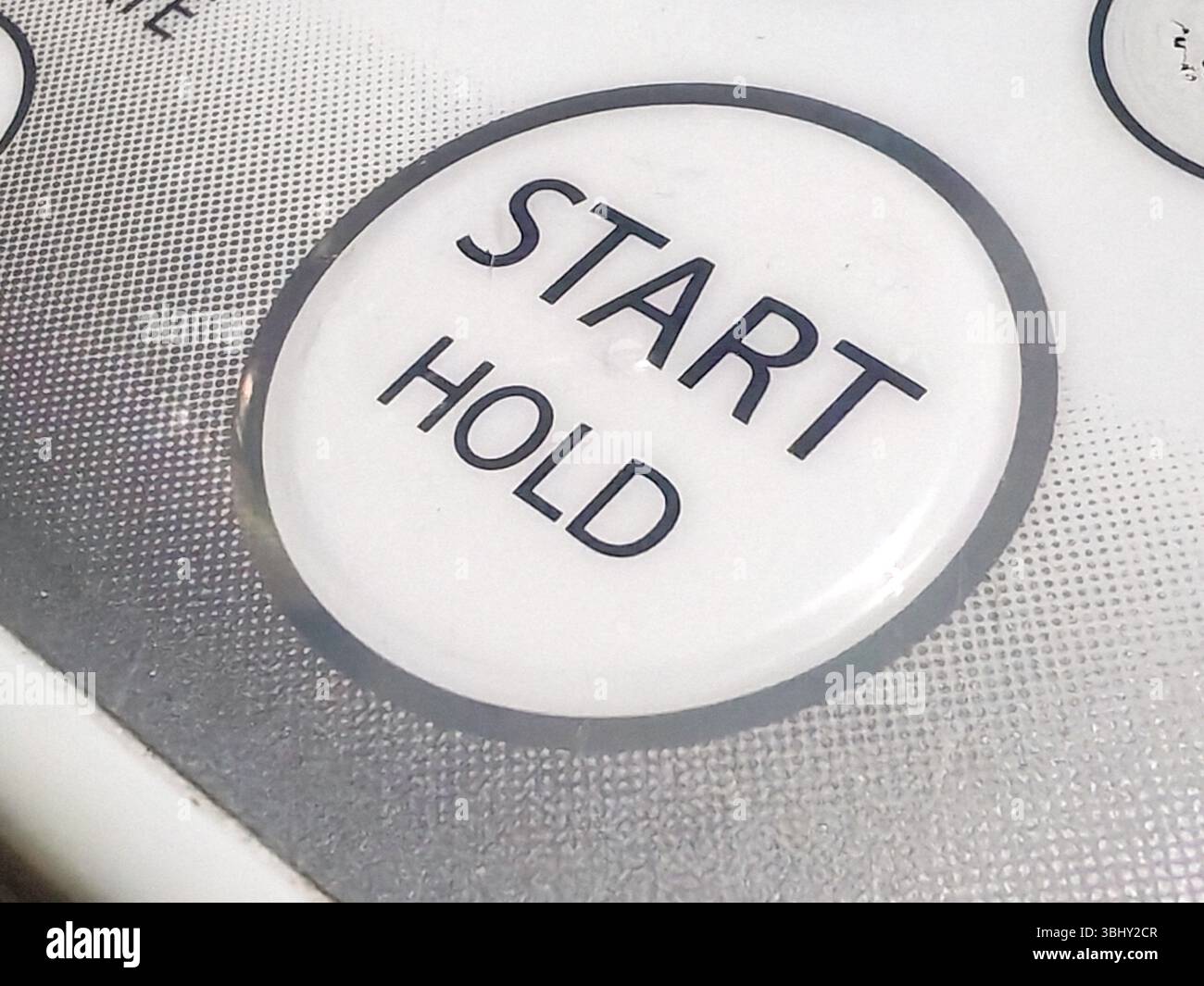 Nahansicht einer Schaltfläche „START HOLD“ auf einem Bedienfeld. Stockfoto