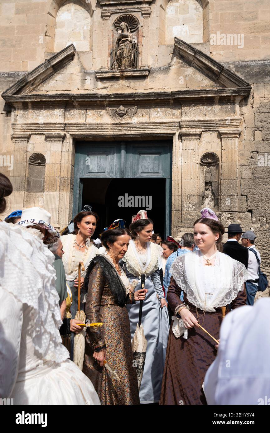 Frauen verlassen die Kirche Norte Dame beim Fete du Kostümfest, bei dem über 500 Frauen traditionelle Kleidung aus ihrer Region tragen, die unterschiedliche La darstellen Stockfoto