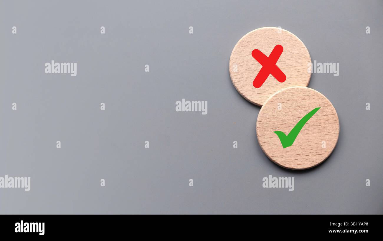 Konzept der Bewertung. Wahr- oder falsch-Symbol. Akzeptiert oder abgelehnt. Ja oder nein Symbol über einem hölzernen Kreis auf grauem Hintergrund. Stockfoto