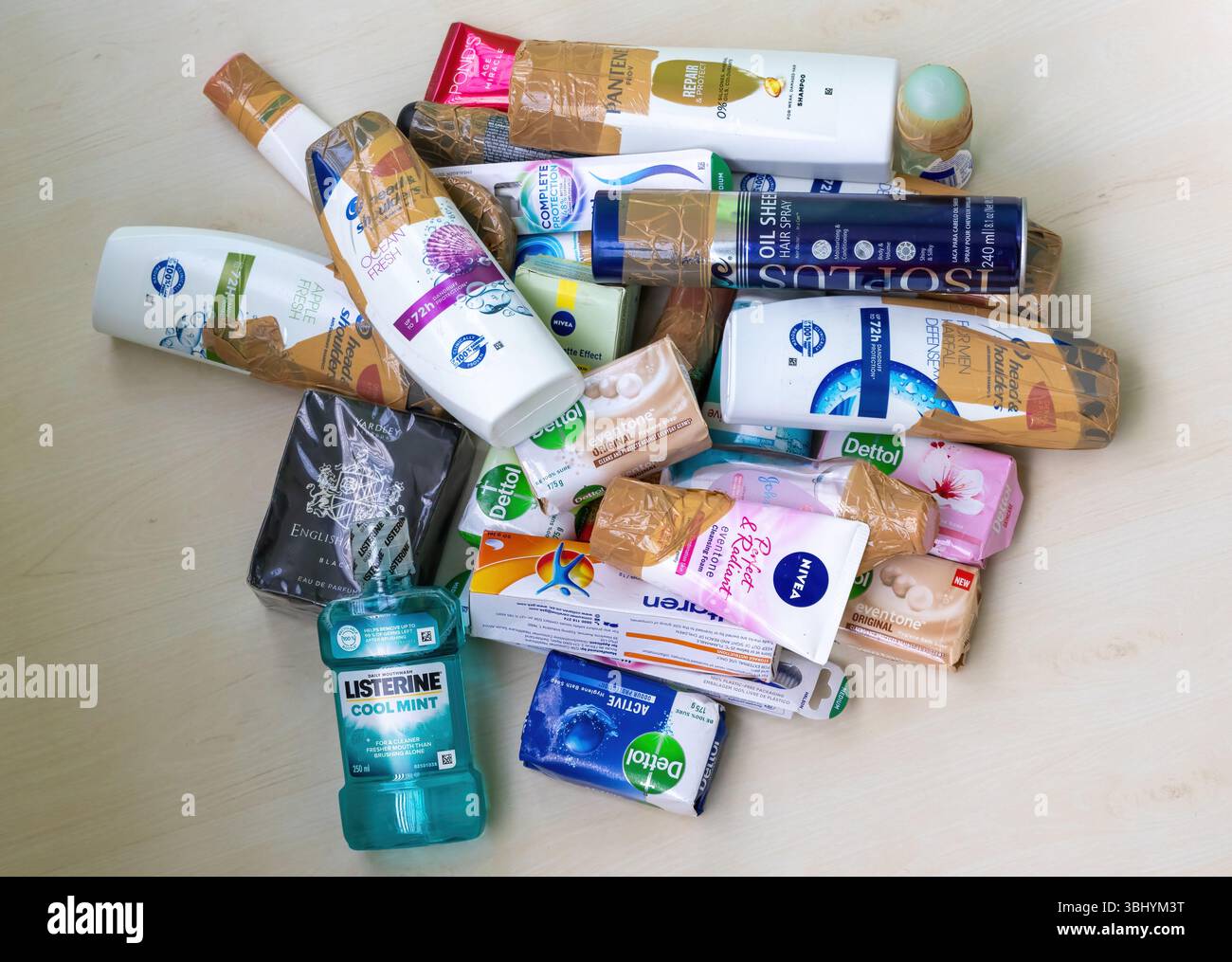 Verschiedene Schönheits- und Kosmetikprodukte werden auf hölzernem Hintergrund ausgestellt, darunter Shampoo, Gesichtswäsche, Creme, Lotion, Parfüm, Körperspray, Zahnvergnügen Stockfoto
