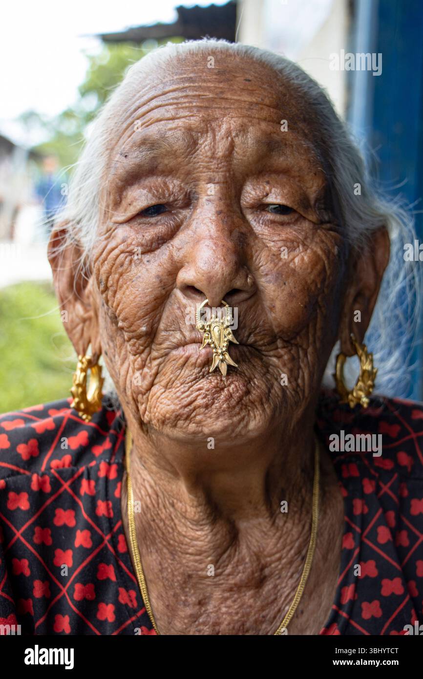 Eine ältere Frau aus der Gemeinde Rai trägt eine Bulaki, eine traditionelle goldene Nasennadel oder Nasendangler. Sankhuwasabha, Nepal. Stockfoto