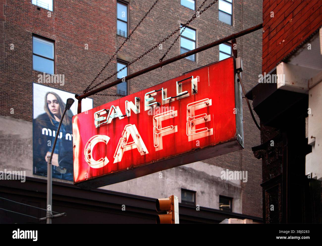 Legendäres, rotes Vintage-Neonschild Fanelli Cafe vor einem Backsteingebäude in urbaner Umgebung mit Straßenwerbung Soho manhattan New york usa Stockfoto