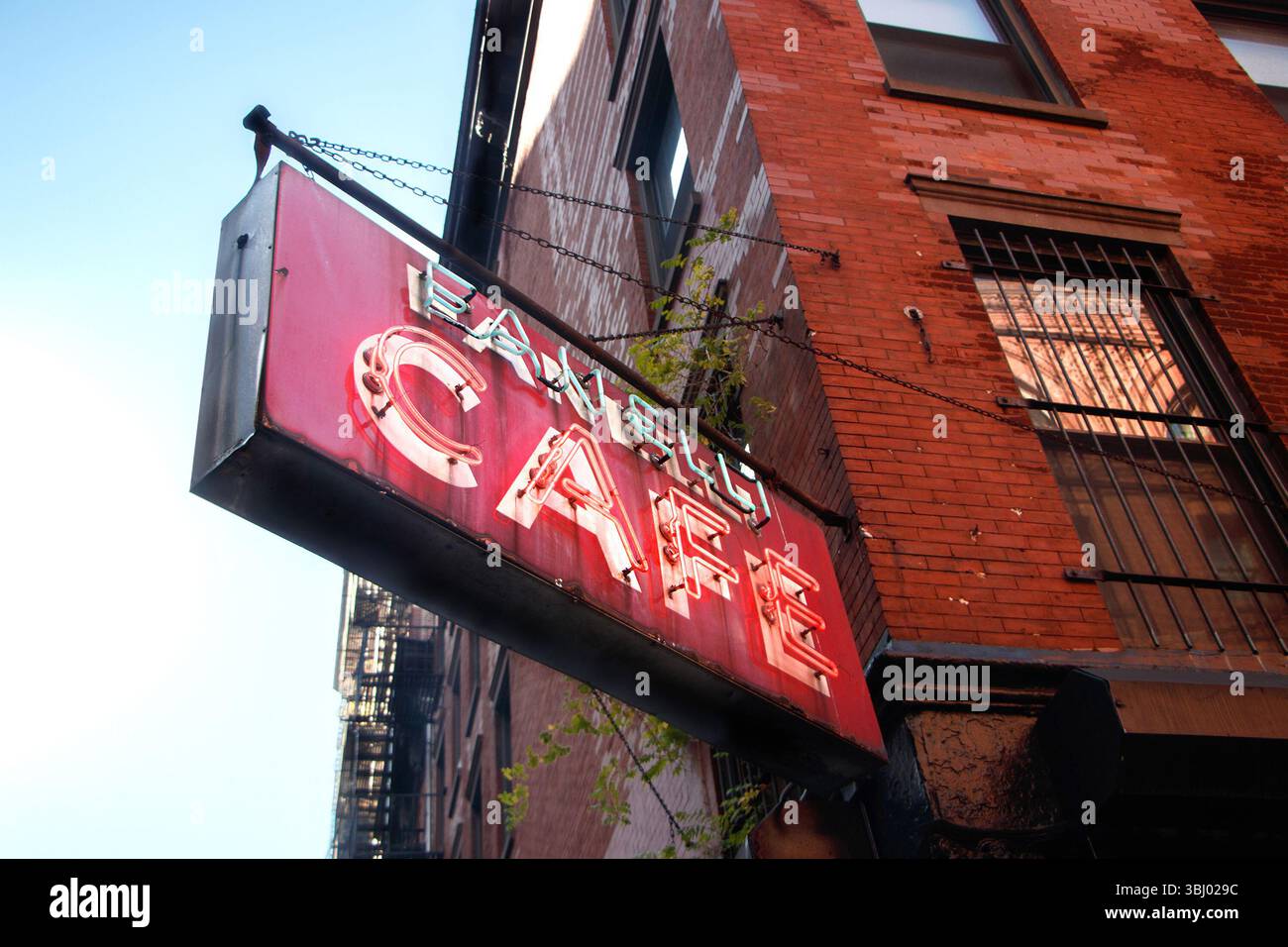 Legendäres, rotes Vintage-Neonschild Fanelli Cafe vor einem Backsteingebäude in urbaner Umgebung mit Straßenwerbung Soho manhattan New york usa Stockfoto