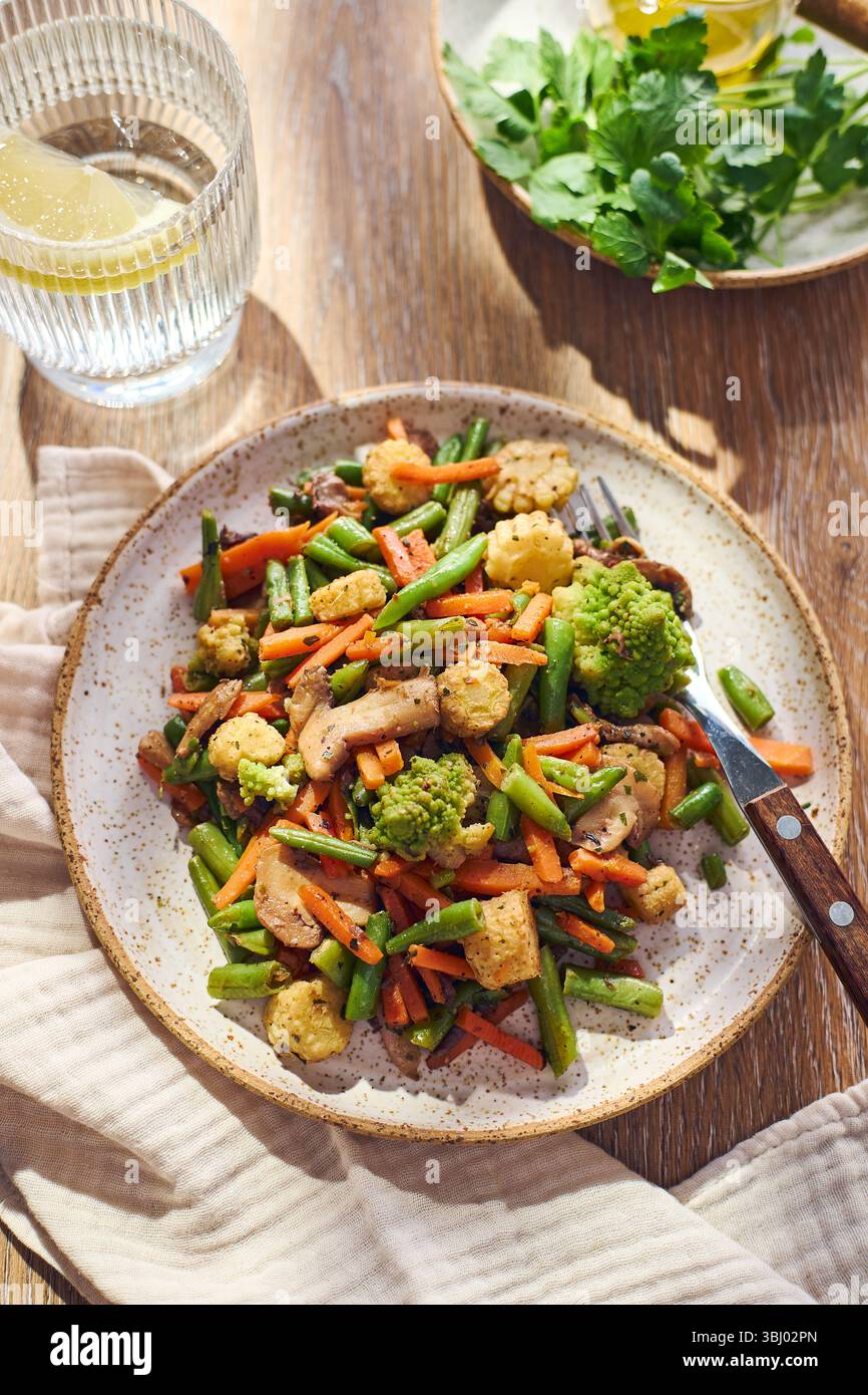 Teller mit gebratenem gemischtem Gemüse mit grünen Bohnen, Karotten, Babymais, Romesco und Pilzen Stockfoto
