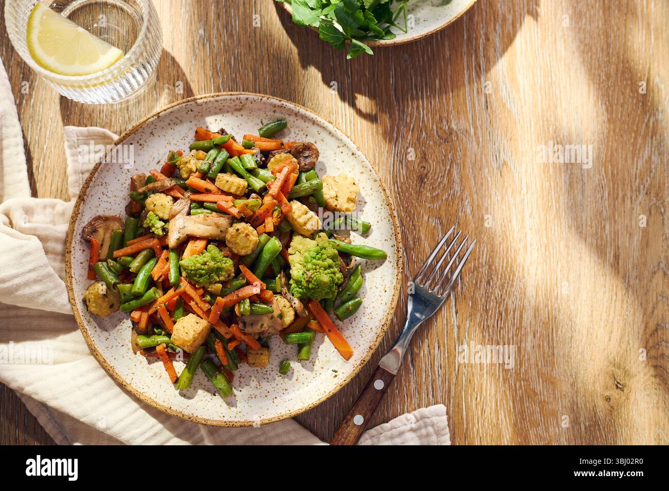 Teller mit gebratenem gemischtem Gemüse mit grünen Bohnen, Karotten, Babymais, Romesco und Pilzen Stockfoto