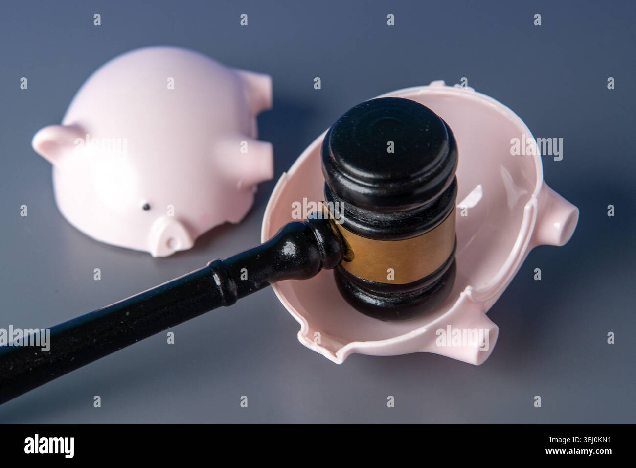 Eine kaputte pinkfarbene Schweinebank und ein Hammer des Richters. Finanzieller Verlust, Konkurs, rechtliche Schritte, Schuldenkonzept. Stockfoto