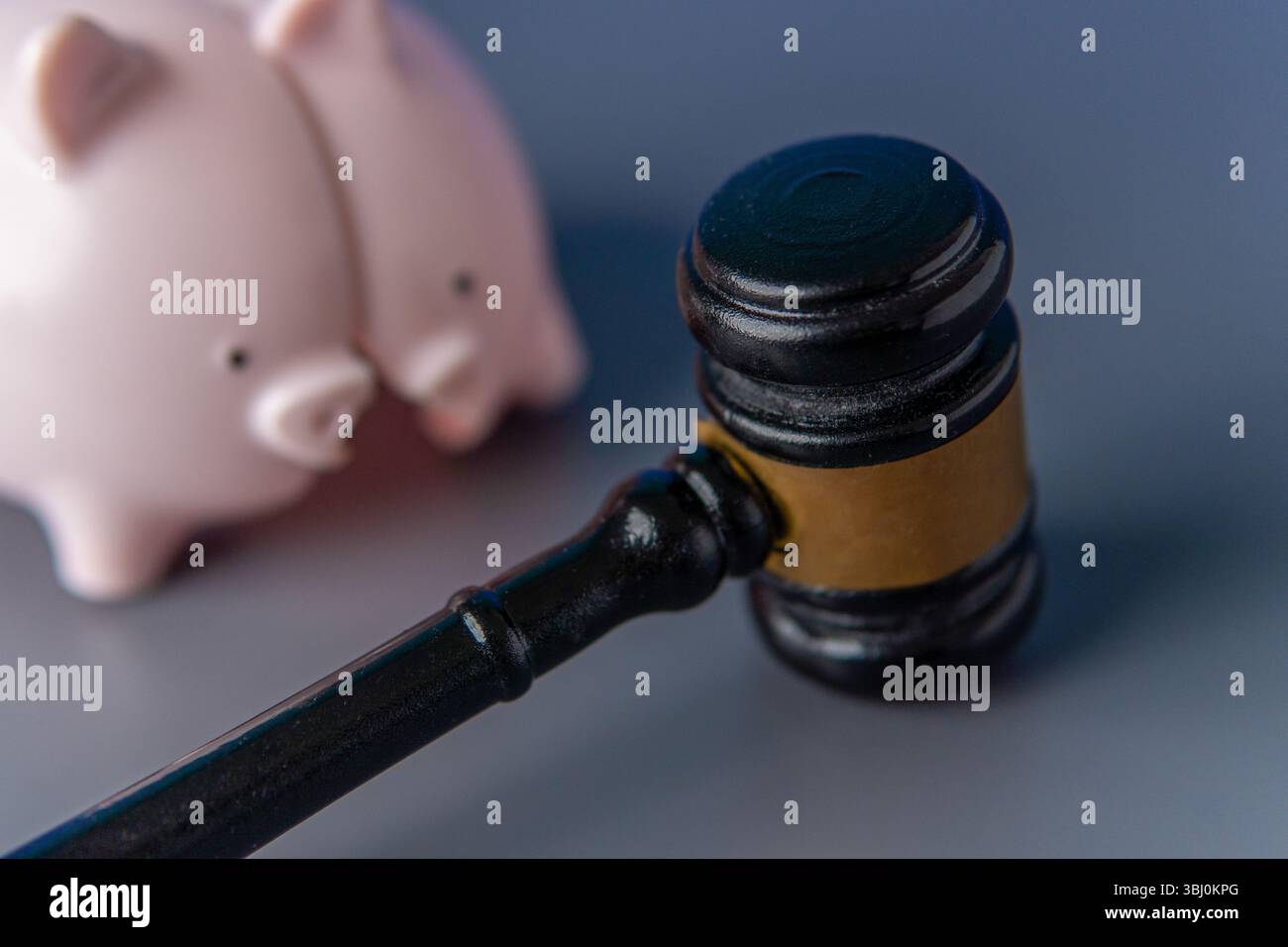 Eine kaputte pinkfarbene Schweinebank und ein Hammer des Richters. Finanzieller Verlust, Konkurs, rechtliche Schritte, Schuldenkonzept. Stockfoto