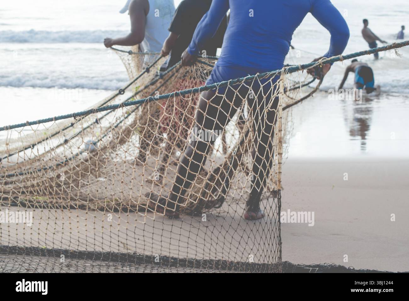 Ein halber Körper von nicht identifizierten Fischern, die ein Fischernetz ziehen. Angelsport. Brasilien Stockfoto