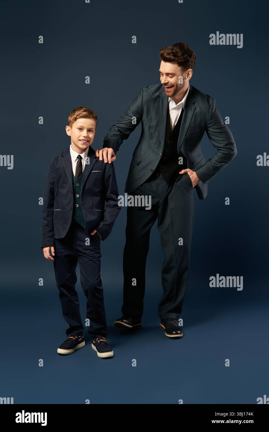 Vater teilt einen freudigen Moment mit seinem Sohn, beide elegant gekleidet für einen festlichen Anlass. Stockfoto