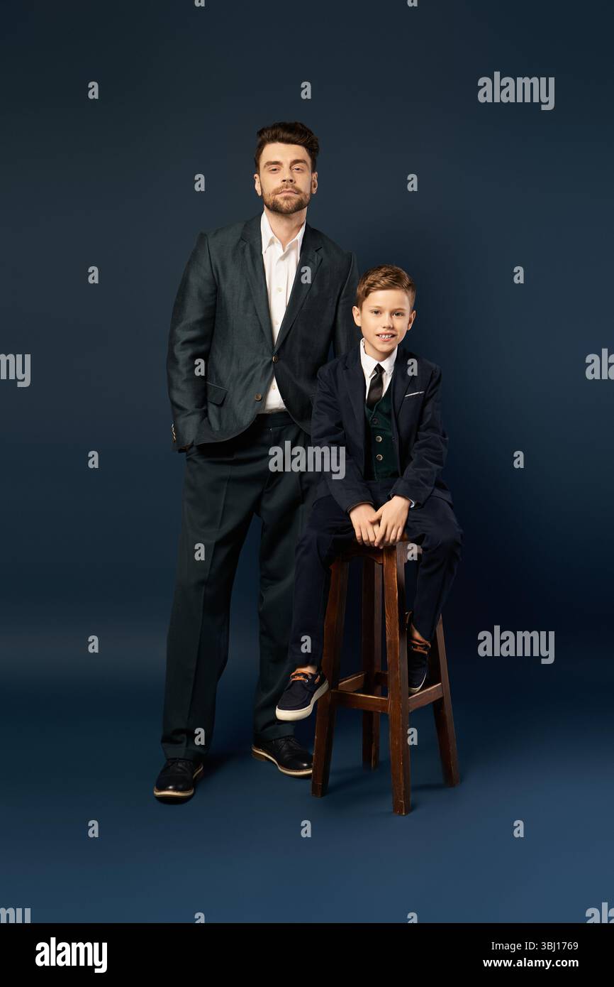 Ein Vater und ein Sohn teilen einen freudigen Moment und zeigen ihre Verbundenheit in eleganten Outfits zusammen. Stockfoto