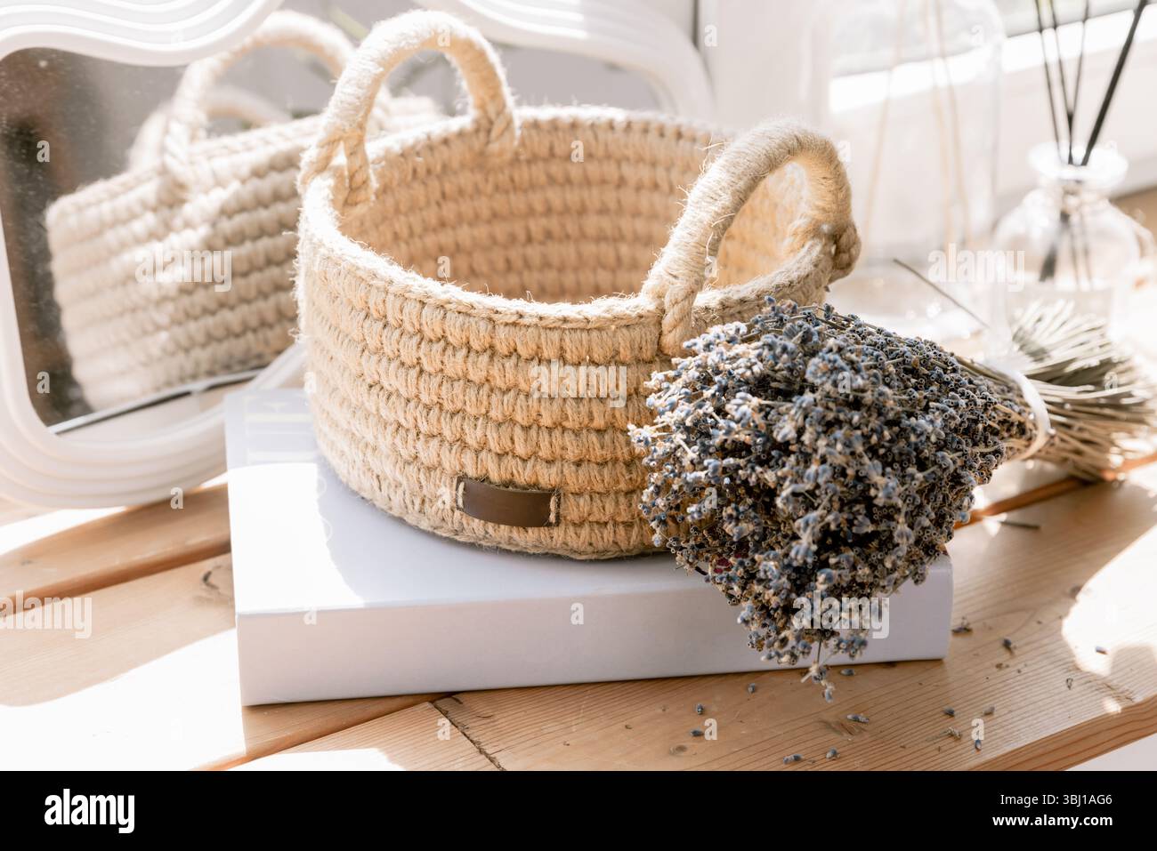 Stilvolle handgefertigte Jute-Tasche, perfekt für umweltfreundliche Innenräume mit Lavendelstrauß Stockfoto